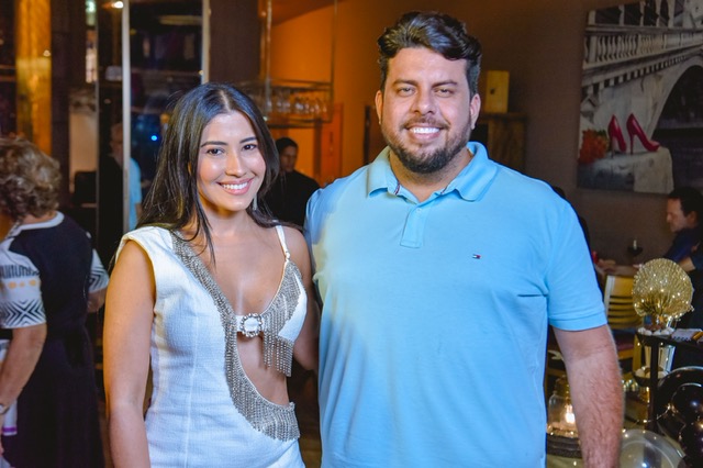 A influencer e apresentadora Thaynara OG linda de branco e prata com o anfitrião da Villa do Vinho Werther Bandeira – Foto: Divulgação