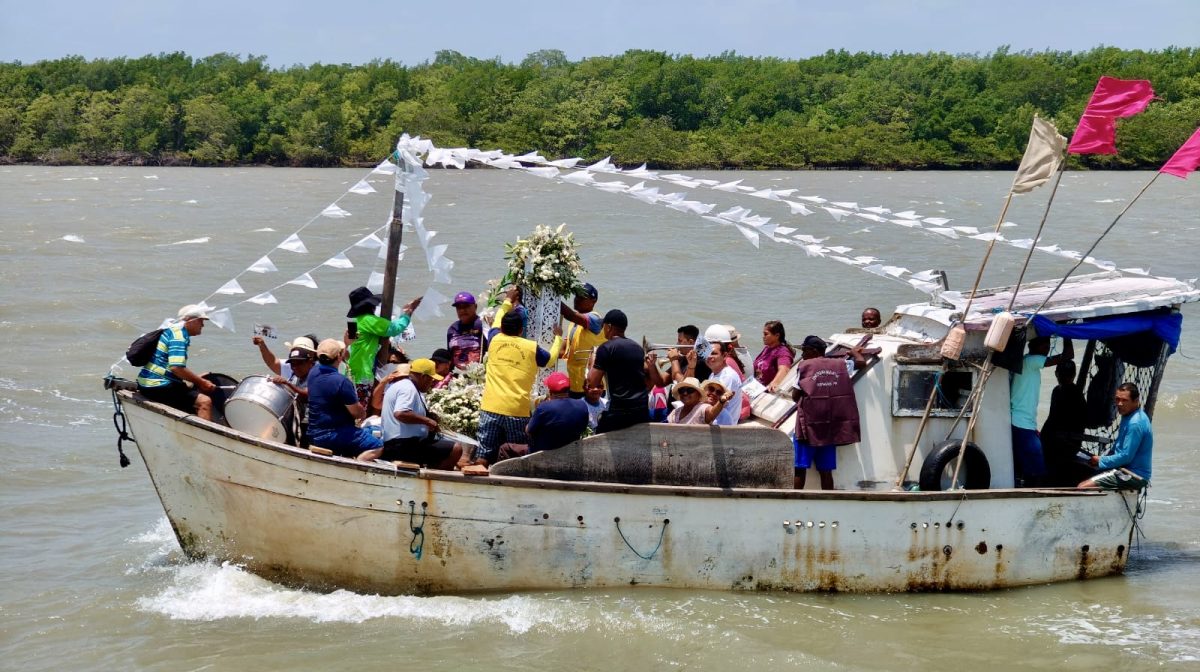 O barco com a imagem de São José lidera a procissão, seguida de vários outros com devotos que cantam ao som da banda – Foto: Iago Azevedo