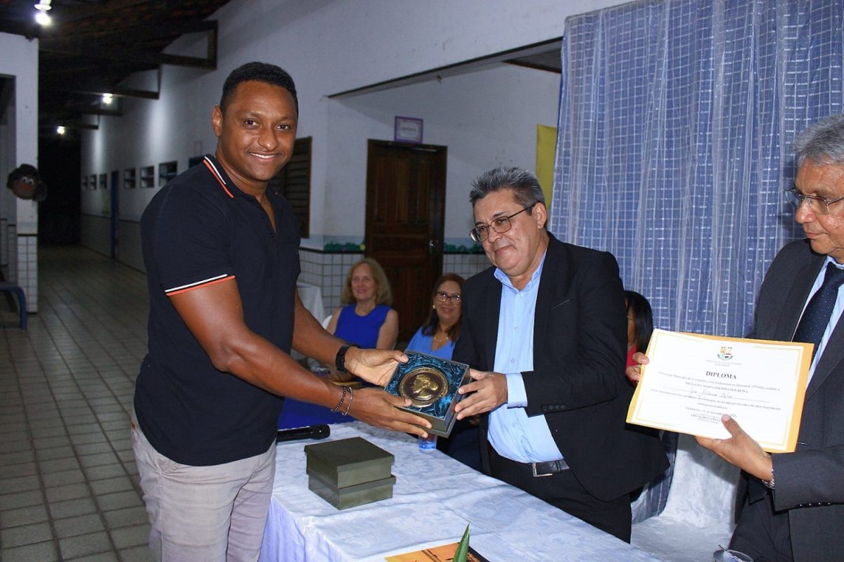 Padre Márcio Cardoso Silva representando seu pai, o compositor José Antônio Silva, recebendo das mãos do Prefeito Osvaldo Gomes e do juiz, Presidente da Academia Vimanarense de Letras, Agenor Gomes, medalha e diploma, respectivamente – Foto: Gutemberg Bogéa 