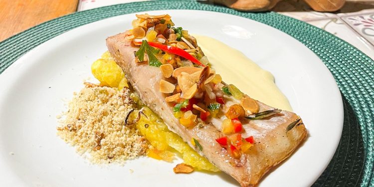 O Peixe Acima do Rebojo tem como ingredientes ventrecha de caranha com crosta de mandioca moqueada na brasa, vinagrete de banana-da-terra, musseline de batata e farofa de baru – Foto: Marzim Aguiar