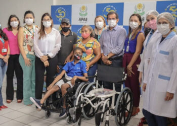 O Presidente da APAE de São Luís Sebastião Vanderlaan Rolim e a Assessora Jurídica da instituição Dra. Conceição Melo Rolim entre a equipe multidisciplinar entregando aos familiares do paciente Messy Silva Trindade uma cadeira de rodas especial e uma cadeira para banho – Foto: Divulgação