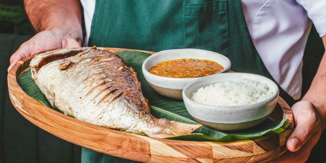 Pargo assado recheado com farofa de banana, servido com arroz e pirão - Foto: Divulgação