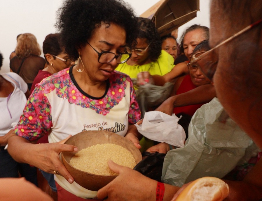 Alda Pinheiro na distribuição de alimentos. Ponto importante do festejo que reúne milhares de fiéis - Foto: Murilo Santos